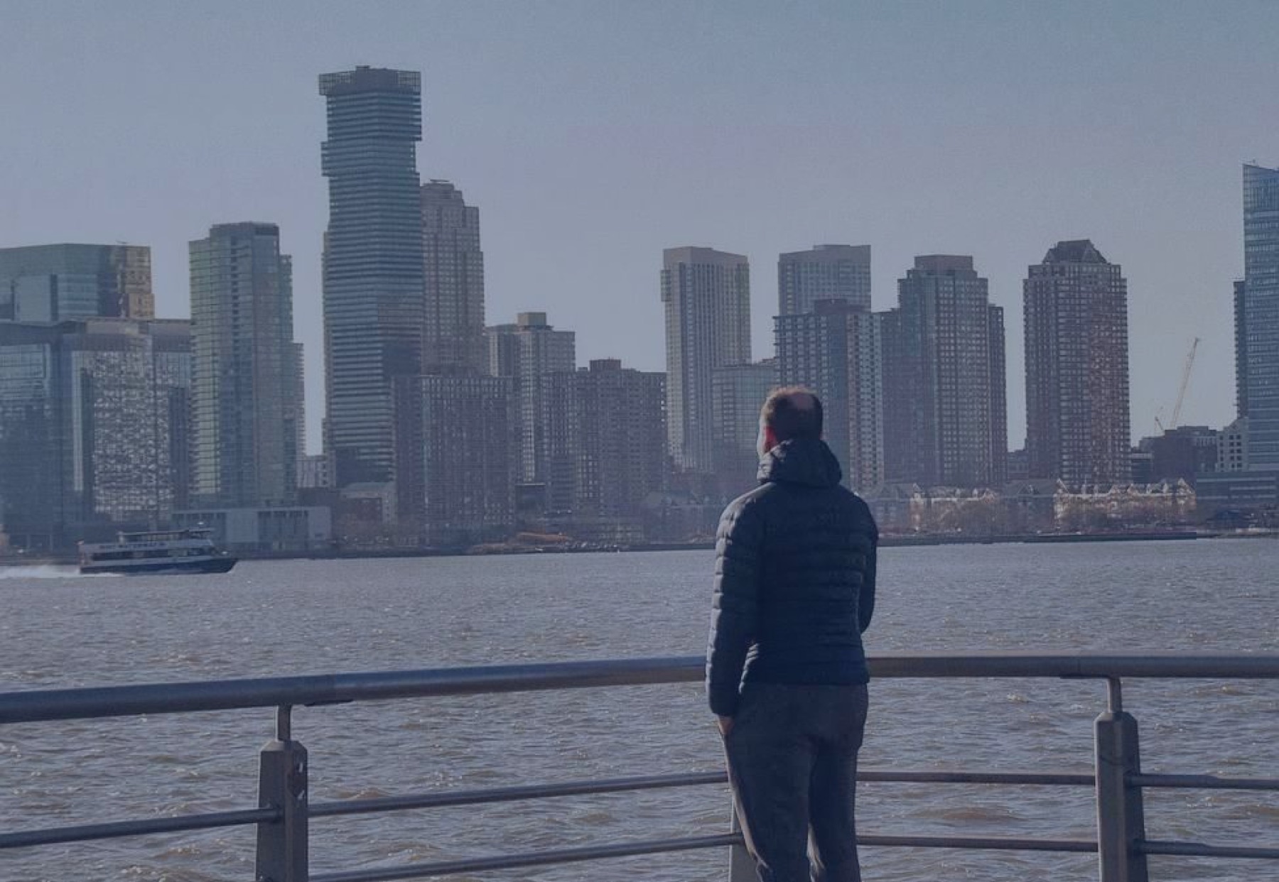 A man looking at the skyline across the Hudson River